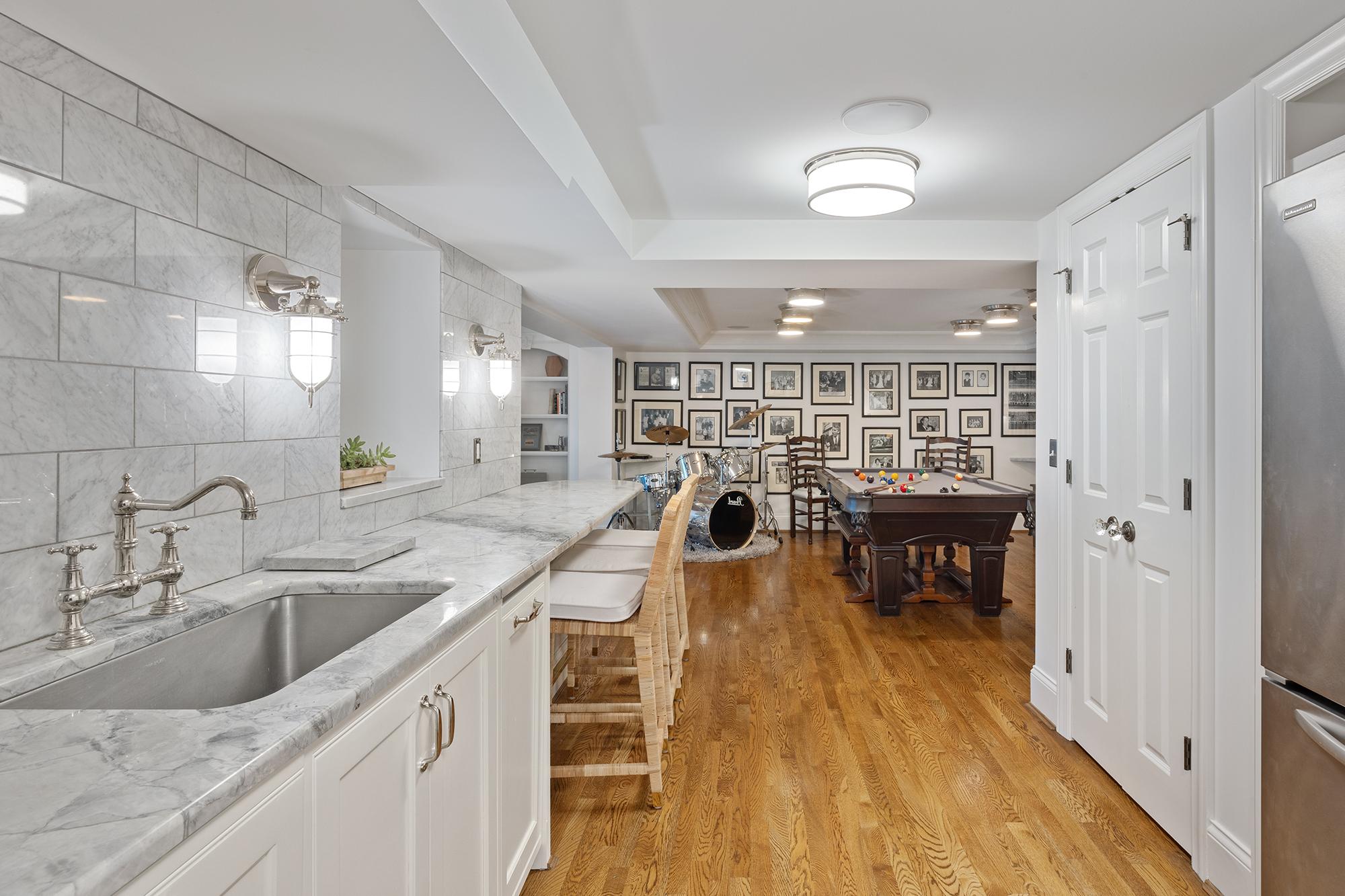 Basement kitchenette, white cabinets, pool table